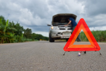 Triangle Red emergency stop sign, broken, damaged cars parked on the street.の写真素材