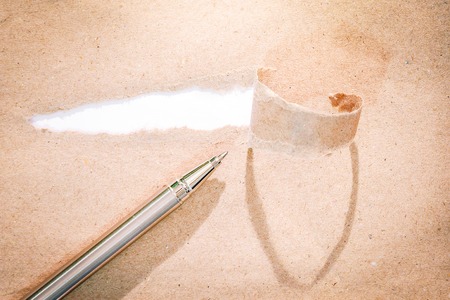 Closeup torn brown paper with white background for text area spaceの写真素材