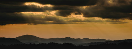 panoramic winter sunset high up in the silhouette mountains