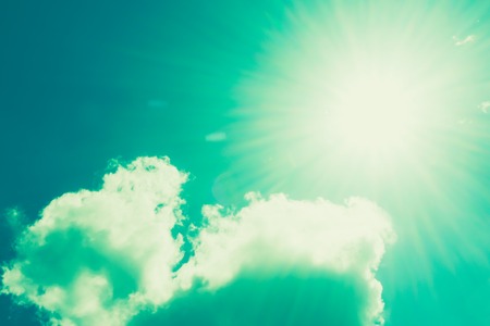 Vintage tone of Realistic shining sun with lens flare on blue sky clouds nature day sky backgroundの写真素材