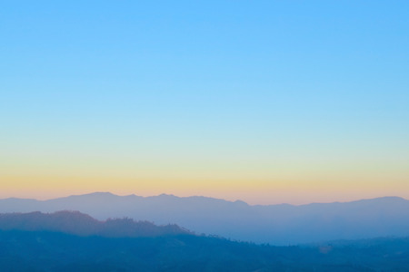 Blurred sunrise orange sky with mountain ,fresh morning nature backgroundの写真素材