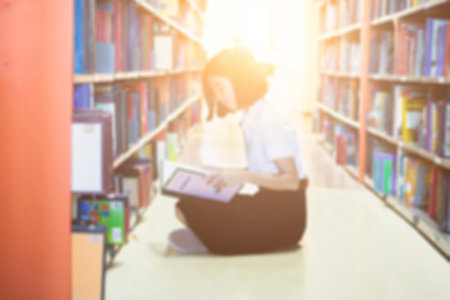 Blurred of Asian student in uniform reading in the library at university and Research Knowlegeの写真素材