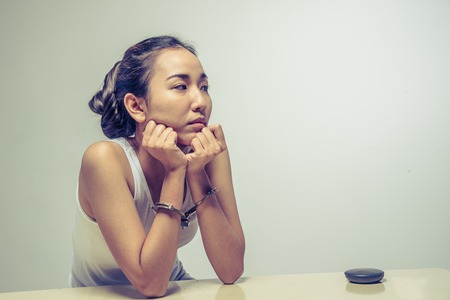 closeup young woman with handcuffs, violence or internment concept backgroundの写真素材