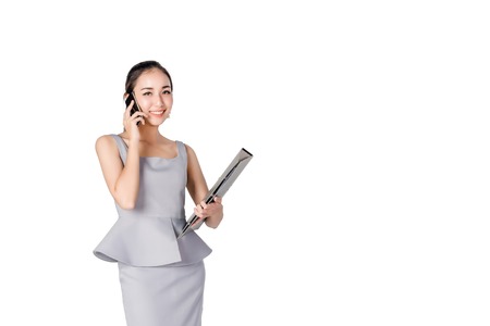 asian businesswoman holding Documents and callingmobile phone isolated on a white backgroundの写真素材
