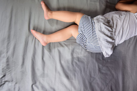 Child pee on a mattress,Little girl feet and pee in bed sheet,Child development concept ,selected focusの写真素材