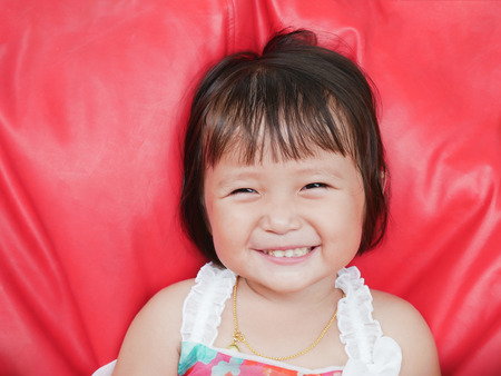 Wide Smiling Little girl with something is stucking in teethの写真素材