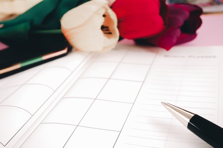 blank planning notebook and pen with flowers on desk use us organizer schedule life or business planner conceptの写真素材