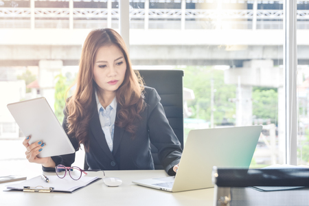 Businesswoman working with tablet and laptop computerの写真素材