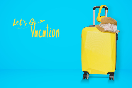 Yellow Suitcases bag with hat on blue background luggage set for copy space. minimal concept. with clipping path on luggage objectの写真素材