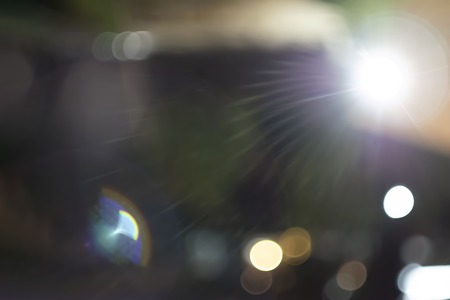 lens flare from vintage lens at night light city for overlay backgroundの写真素材