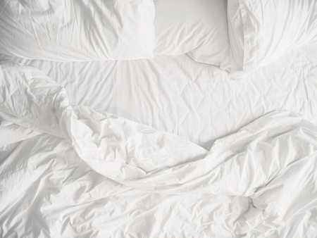 Top view of unmade bedding sheets and pillow ,Unmade messy bed after comfortable sleep conceptの写真素材