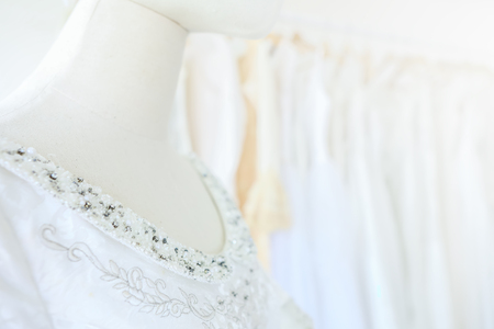 Closeup beautiful bridal dress on a hangers model in wedding dress storeの写真素材