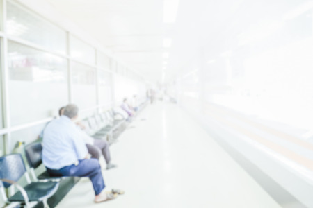 Abstract blurred people waiting in corridor hospital interior background with defocused effect.