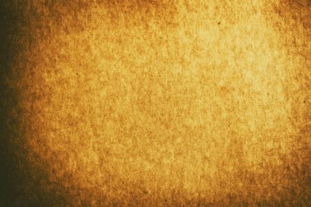Full frame old gold brown paper texture background with vignette for design backdrop or overlay designの写真素材