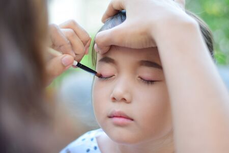 little girl getting her face for makeup by makeup artistの写真素材