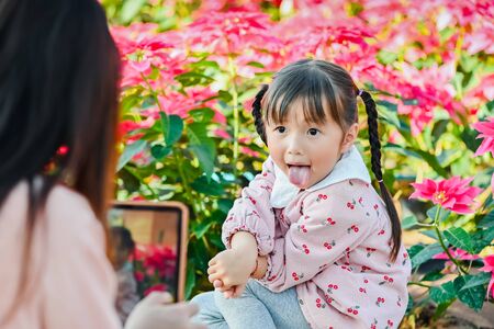 Mom takes pictures of her daughter on vacation traveling time. Cute little asian girl smiling happy face when taking photoの写真素材