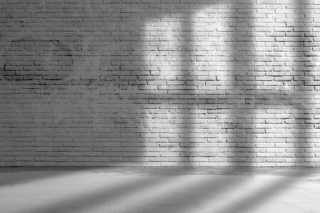 Old grunge rough dark gray brick wall wall with window shadow and concrete floor texture background.の写真素材