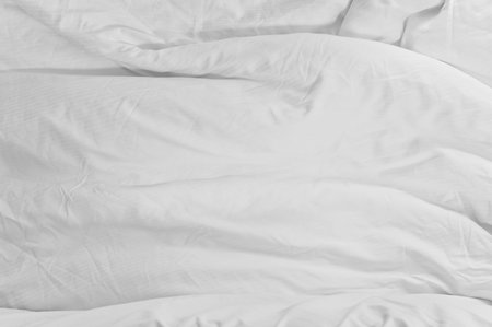 White messy blanket bedding sheet after night sleep,white fabric wrinkled texture Top view