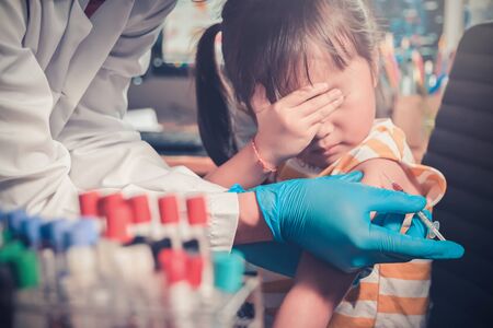 Asian Little child having Injection,Close-up Doctor injecting vaccination to arm of little girl vaccine injection in clinic hospital for immune,health and medical concept,4-6 years old.の写真素材
