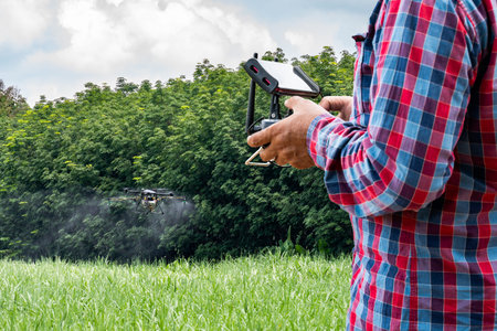Man hand agriculture drone fly to spray fertilizer on the sugarcane fields. Industrial agriculture...