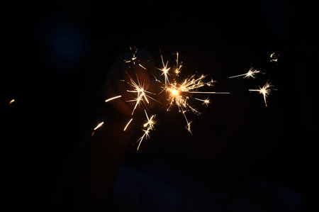 Hand holding firework sparkle exposed texture in celebrating night
