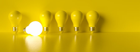 power on Idea light bulb on a vivid yellow background concept for ideas or innovation or saving energyの写真素材