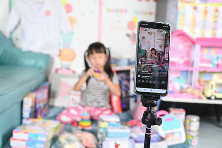 lThailand - April 1 , 2021 ittle girl selling toys online by smartphone live streaming, business online e-commerce at home conceptのeditorial素材