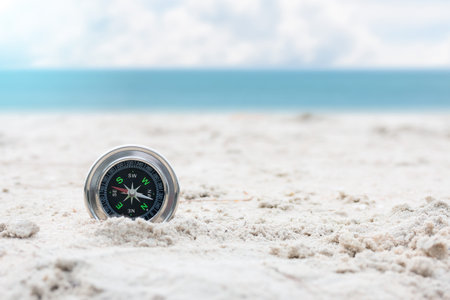 Vacation day nature relaxing with compass on sand beach and sea and blue sky background. copy space.