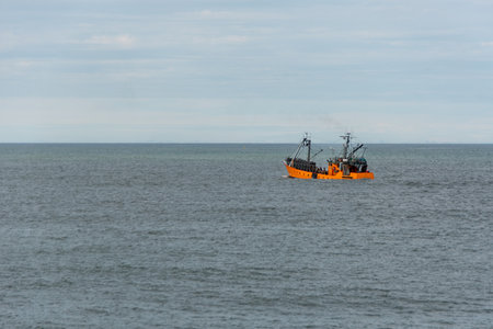 orange fishing boat in the seaの写真素材