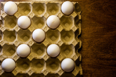 Eggs in carton box on wooden background. Top view.の写真素材
