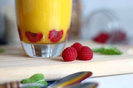 Three raspberries with mango smoothie.の写真素材