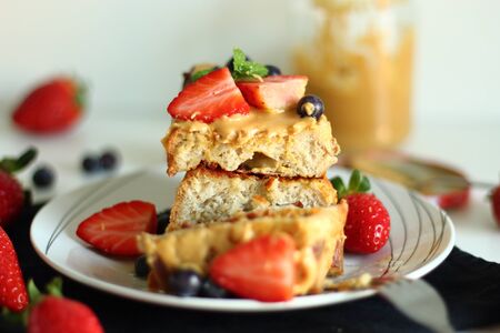 French toast with strawberries, blueberries and peanut butter.の写真素材