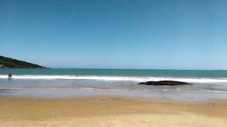 Beach with stone and bather to the horizonの写真素材