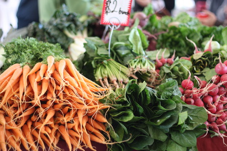 Carrots, spinach, radishes and other vegetables for sale at a farmers marketの写真素材