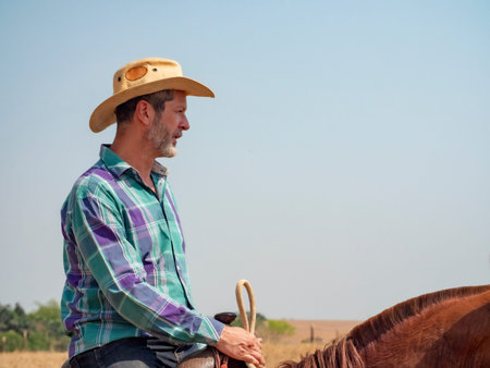 Cowboy is riding his horse on a cattle farm with dry landの写真素材