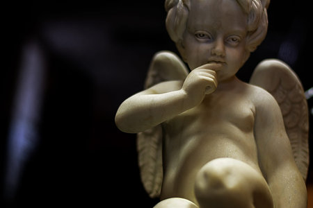 Photo sculpture angel cupid boy in dark colorsの写真素材