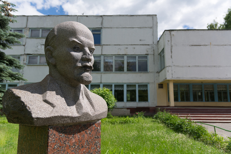 Photo of Old Lenin's bust against the background of the old Soviet buildingの写真素材