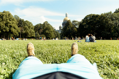 Photo of a man lying in the Alexandrian Park on a summer sunny day in the city of St. Petersburg, Russiaの写真素材