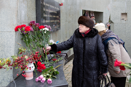 Yoshkar-Ola, Russia - October 30, 2017 Unknown woman lays flowers at the monument to the victims of political repression in Yoshkar-Ola, Russiaのeditorial素材