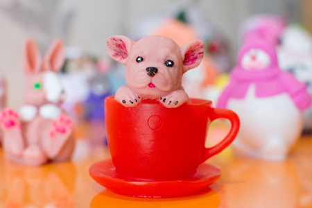 Decorative handmade soap of the original design in the form of a puppy peeking out of a cupの写真素材