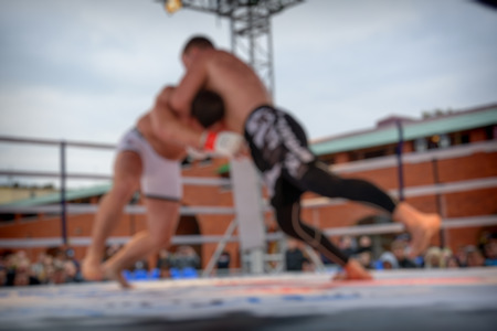 Blurred fighters MMA during the fight in the ring for use as a backgroundの写真素材
