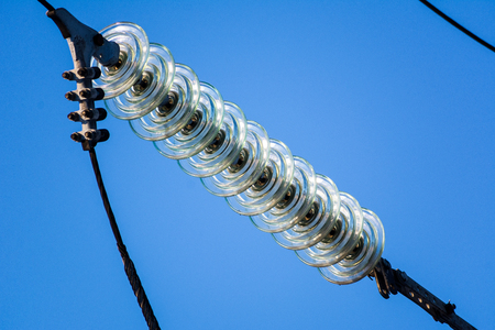 High-voltage electrical insulator electric line against the dark blue skyの写真素材