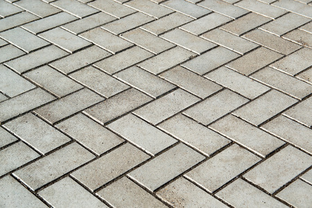 Photo of the site from the old paving slab with small defects and cracks, leaving in perspective. Street coverage of pedestrian areas and paths in parks in daylight outdoorsの写真素材