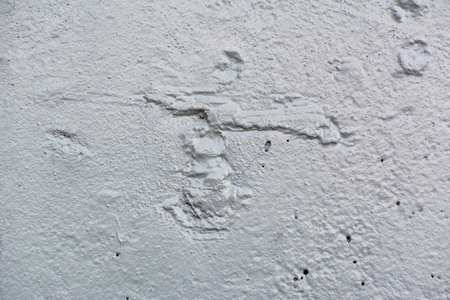 Texture of the surface of an old antique wall with a plaster layer destroyed from moisture, a lot of cracks, irregularities, blisters on the wall, abstract backgroundの写真素材
