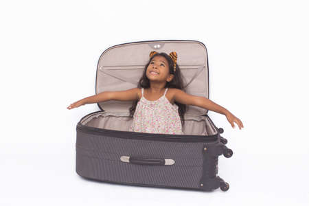 Beautiful girl playing inside a suitcase, isolated on white.の写真素材