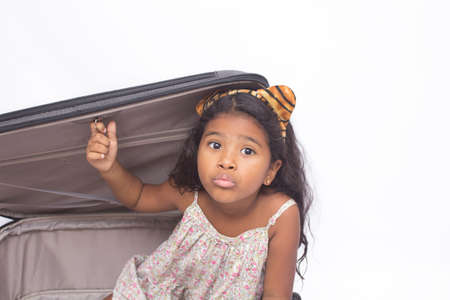 Child inside a suitcase pouting. Isolated on whiteの写真素材