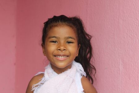 Portrait of cute little girl. She's got your old wooden door. African-American mixed race child.の写真素材