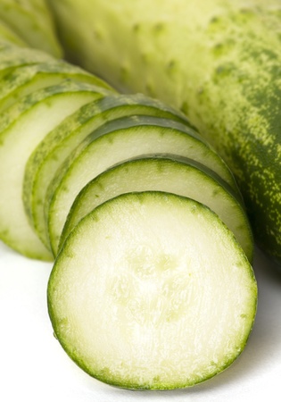 Sliced cucumber next to whole cucumberの写真素材