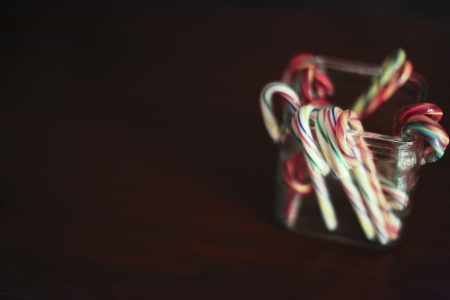holiday candy canes in a glass jar with dark backgroundの写真素材