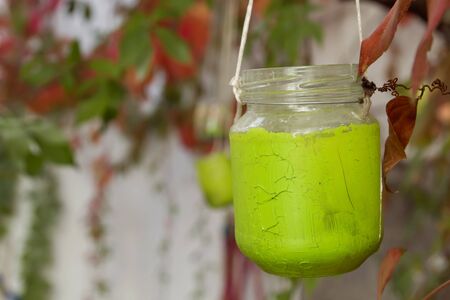 Green painted recycled glass jar as garden lampの写真素材